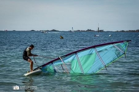 Un surfeur sur sa planche à voile